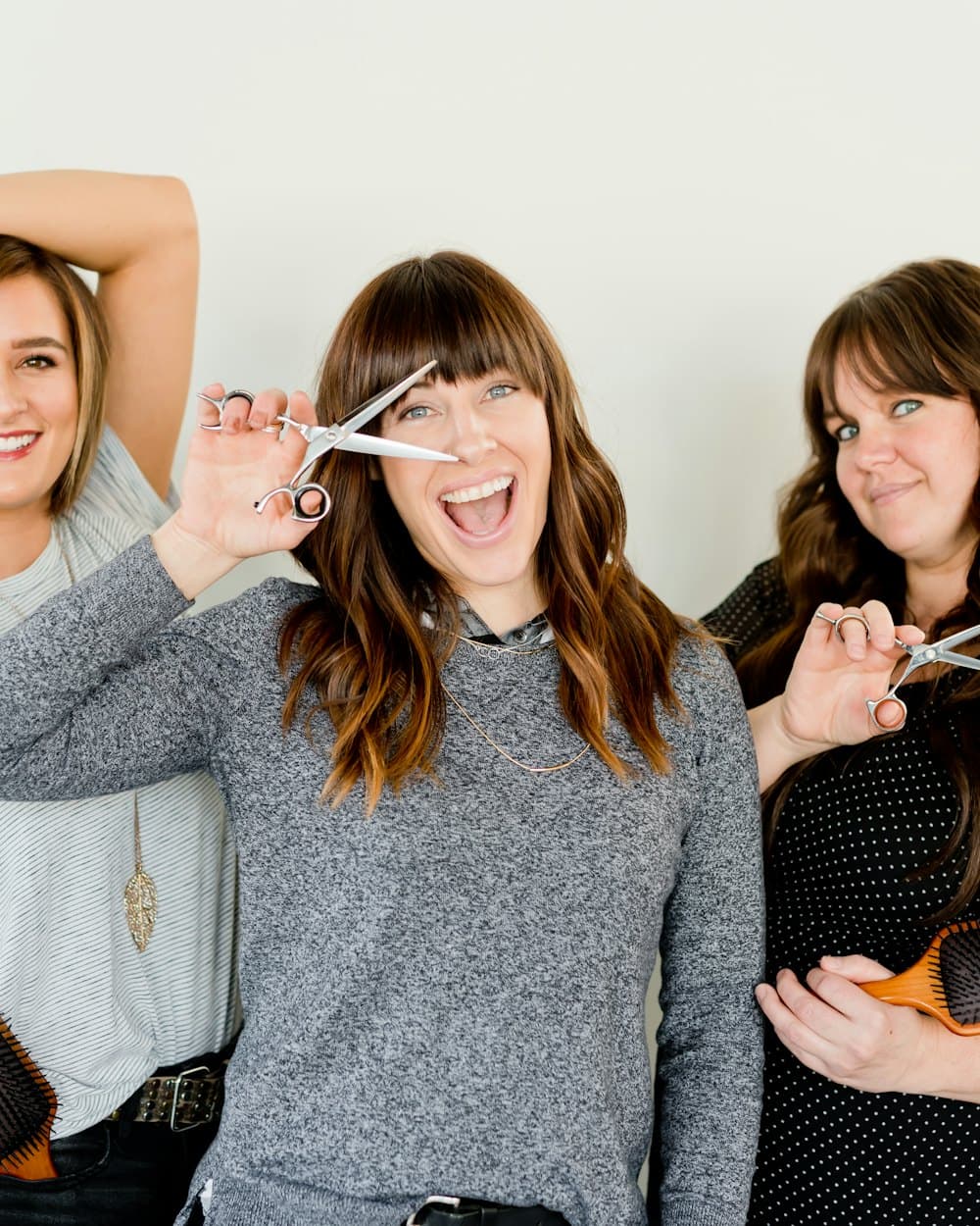 Three stylists from the team laughing together in the studio